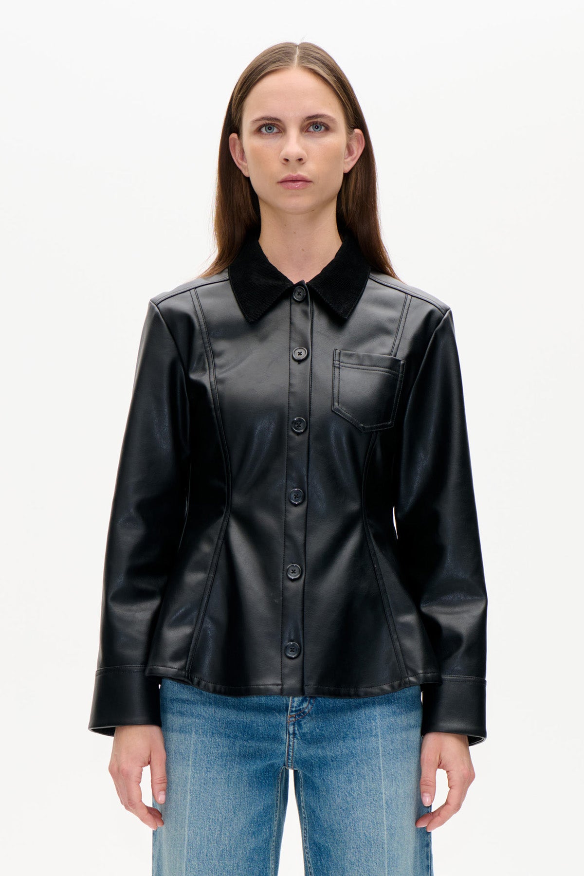 Front view of a black button-front jacket with a contrasting collar, curved seams and a chest pocket, worn with blue jeans.
