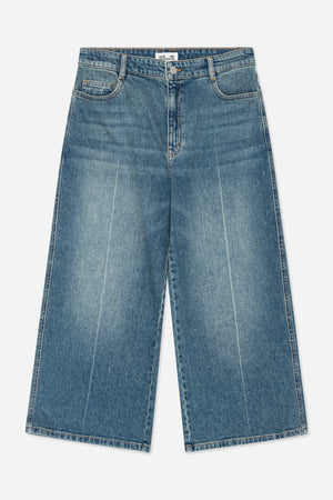 Forfra: blåvaskede jeans i denim med orange syninger, bæltestropper, knapgylp og buede forlommer.