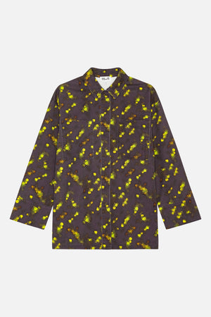 Front view of a long-sleeved collared shirt with two patch pockets, in charcoal fabric with scattered bright yellow and green floral print.