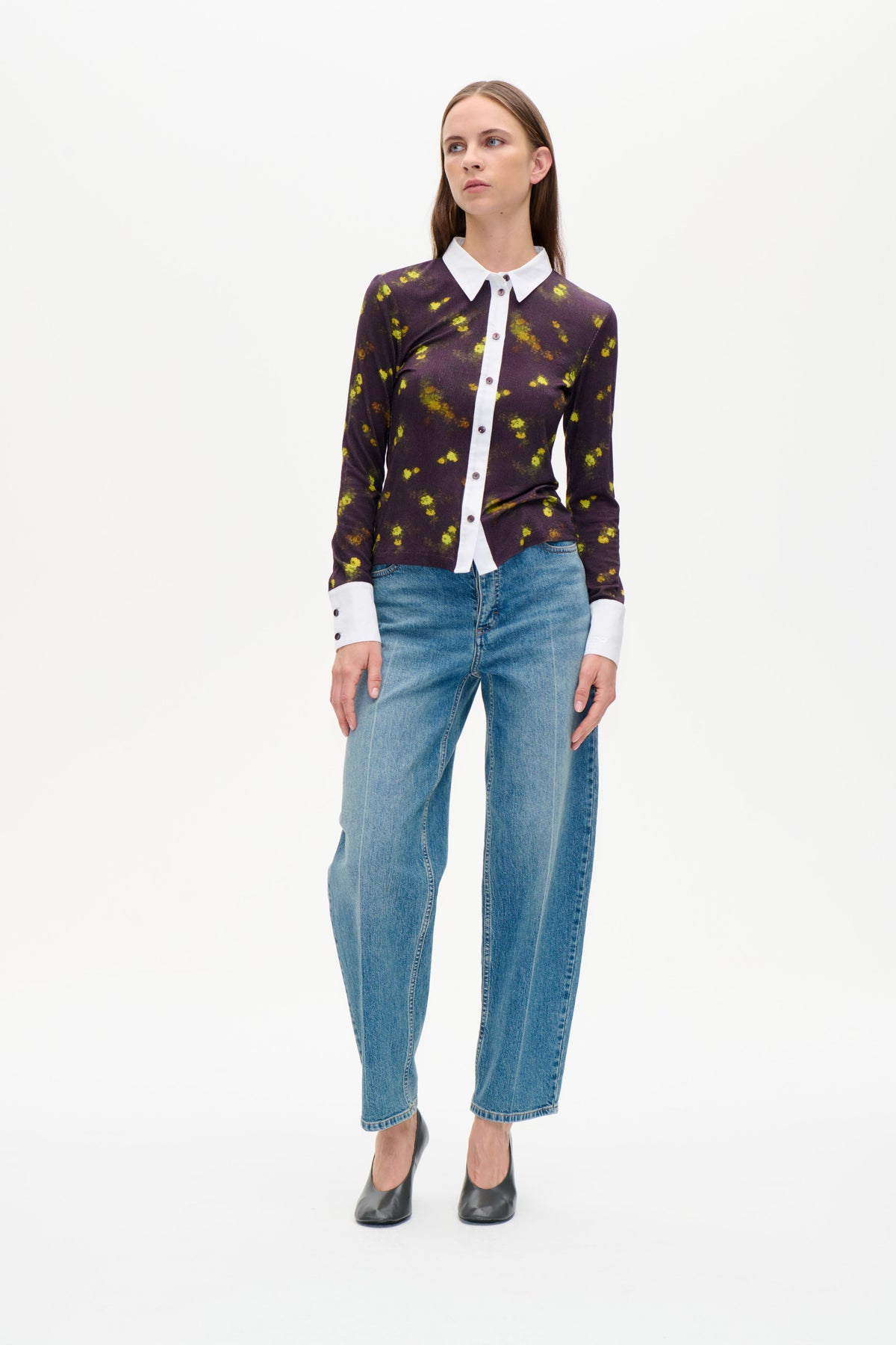 Set forfra: mørkelilla langærmet skjorte med knapstolpe og gule blomsterprint, hvid krave samt manchetter, stylet med blå jeans.