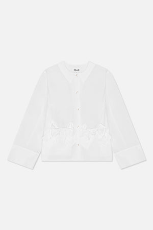 Set forfra: en hvid bluse med lange ærmer, rund hals, blanke knapper, brede manchetter og oversized sløjfedetaljer i taljen.