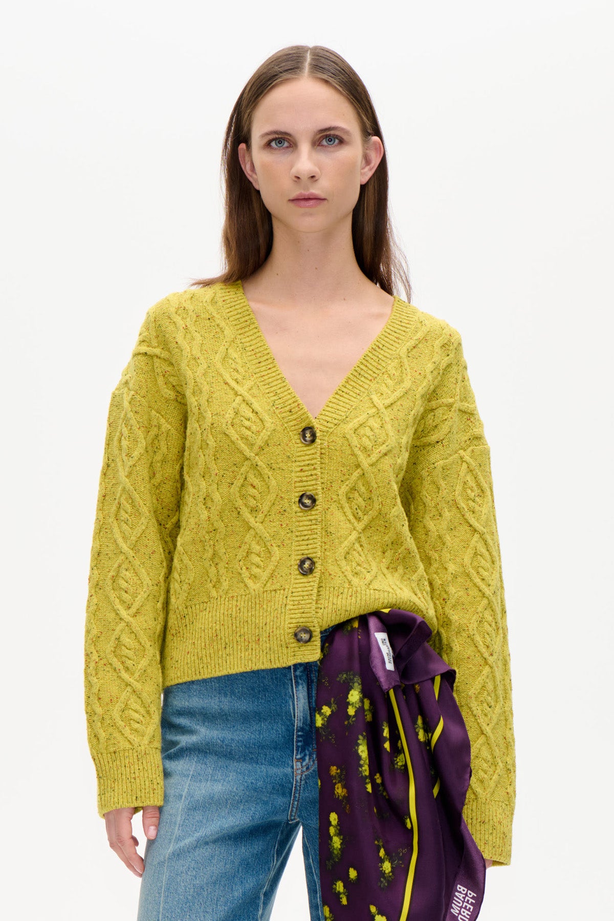 Set forfra: limegul flettestrikket cardigan med v-hals, lange ærmer og mørke knapper, stylet med blå jeans.