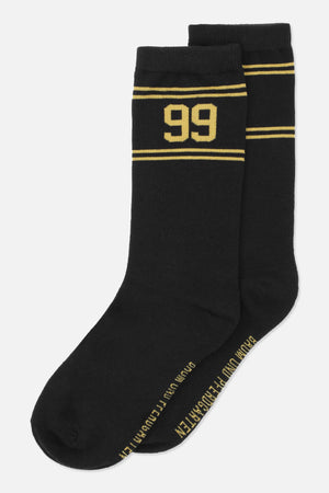 Par sorte crewstrømper med gule striber og et stort '99' på det ene skaft, vist skråt.